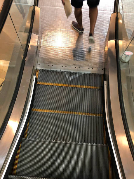 istock Image of unrecognisable person using metal steps on an escalator with large white, spray painted ticks, Coronavirus social distancing regulations on moving staircase steps, Covid-19 safety 1282029920