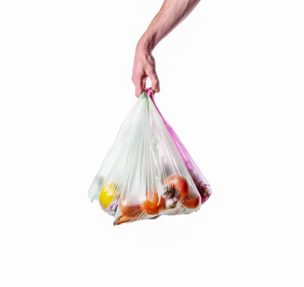 istock Man holds plastic bags with vegetables isolated on white 1282030536