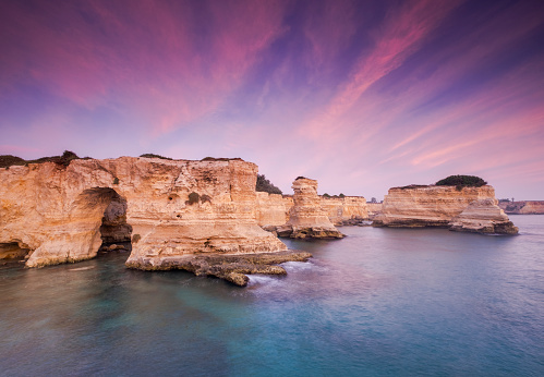 the stacks of Sant'Andrea at the first light of dawn, in Puglia