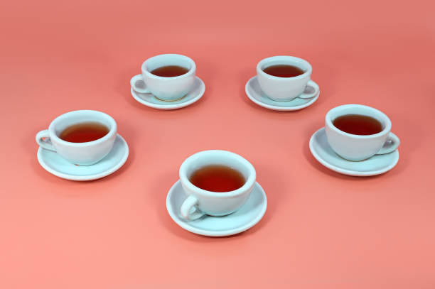 istock Toy cups with saucers and tea on a pink background 1282037029