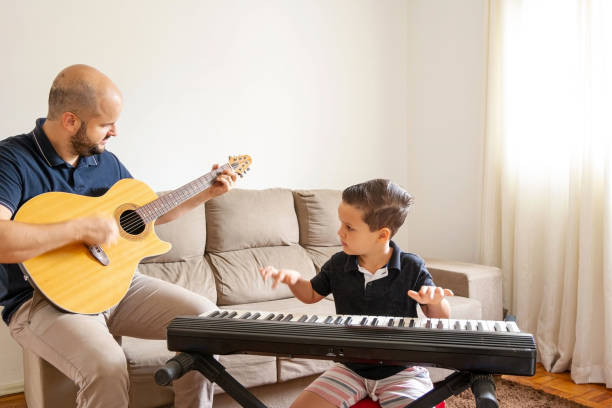istock Father and son playing music at home. 1282039314