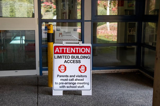 View of sign"Attention, limited building access" at the entrance of local school in Sayward, Canada stock photo