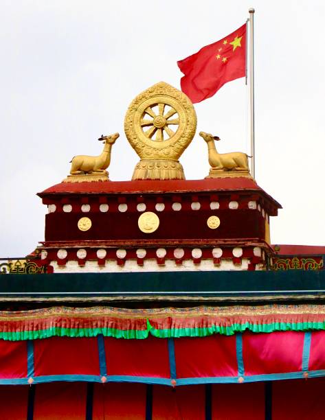The photo shows the golden dharma wheel and pair of deers on top of the Jokhang (the most sacred temple in Tibet) in Lhasa. The two are Buddhist symbols which stand on the roof of all Tibetan temples / monasteries. The dharma wheel represents the teaching of the Buddha to his disciples, whereas the two deers refer to the disciples on the first occasion of his teaching, at the Deers Park in Sarnath. On top of many Tibetan monasteries, close to the two Buddhist symbols, the Chinese flag is also fluctuating in the wind.