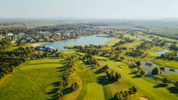 ponto de vista drone de um resort de golfe com poços de areia, árvores e lagos. - golf course golf sand trap beautiful - fotografias e filmes do acervo