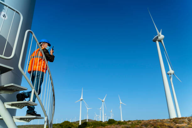 istock Young engineer man with face mask looking and checking wind turbines at field during pandemic 1282045973