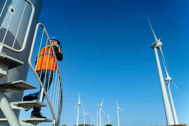 istock Young engineer man with face mask looking and checking wind turbines at field during pandemic 1282046760