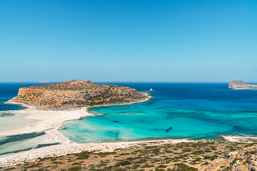 Vibrant blue lagoon and Balos beach on paradise Greek island Crete. Turquoise blue water in the sea on a sunny day in the summer.