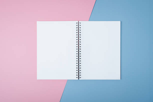 istock Blank spiral notebook on pastel background. Flat lay of home office desk, Office concept. 1282062033