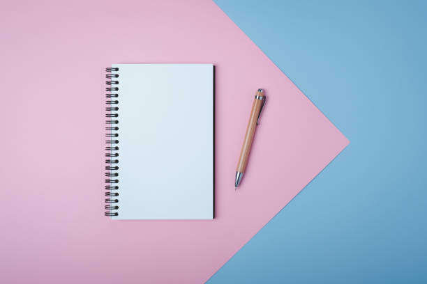 istock Blank spiral notebook on pastel background. Flat lay of home office desk, Office concept. 1282062047