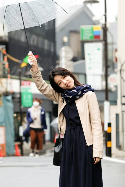 portrait of smiling woman on rainy city street - shower women water outdoors imagens e fotografias de stock