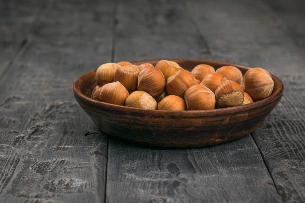 istock Hazelnuts in their shells in a clay Cup on a wooden table. 1282071350