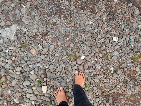 Lumajang, East Java, Indonesia. Someone tries to walk on the gravel barefoot.