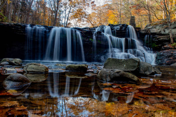 istock Waterfall reflections in autumn in the mountains 1282075451