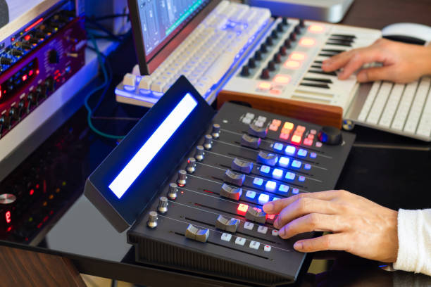 istock Sound engineer hands adjusting volume on digital audio control surface for mixing audio tracks on computer. Post production, broadcasting, recording concept 1282077860