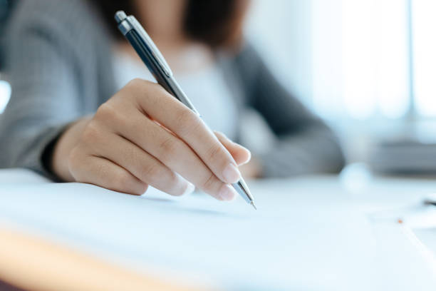 istock Hand high school or college students hold pen and learning tutoring on desk and reading, doing homework, lesson practice preparing exam. Education concept. 1282081790