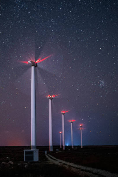 erneuerbare energiesysteme. windturbinenkraftwerk park in der nacht, arbeiten unter dem sternenhimmel und der milchstraße. verschwommene bewegung. - industry dusk night sustainable resources stock-fotos und bilder