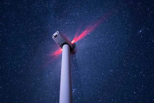 системы возобновляемых источников энергии. освещенная ветровая турбина ночью, работающая под звездным небом и млечным путем. размытое дви� - industry dusk night sustainable resources стоковые фото и изображения