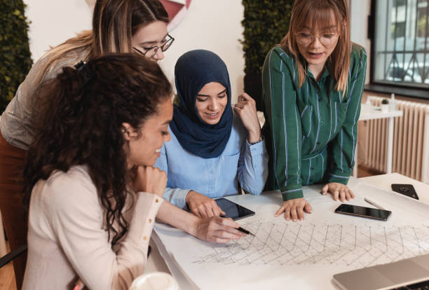 istock Group of modern multicultural young women in creative office. 1282093992