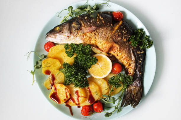 레몬 조각으로 장식된 튀긴 생선과 감자를 클로즈업 - trout prepared fish whole grilled 뉴스 사진 이미지