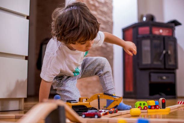 istock Little boy playing with a railroad train toy and plastic vehicle. 1282098026