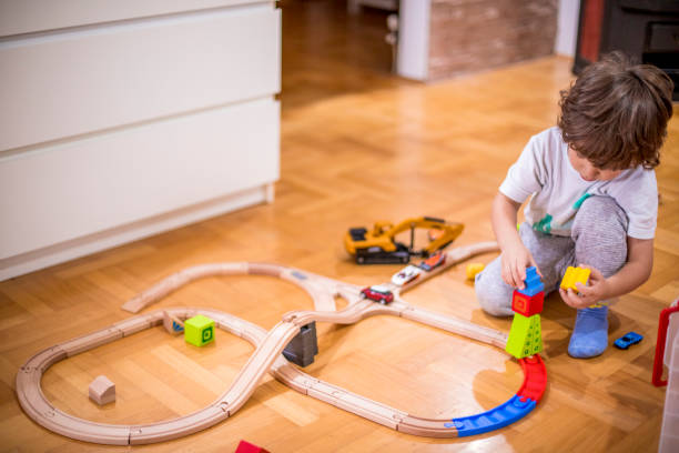 istock Little boy playing with a railroad train toy. 1282098087