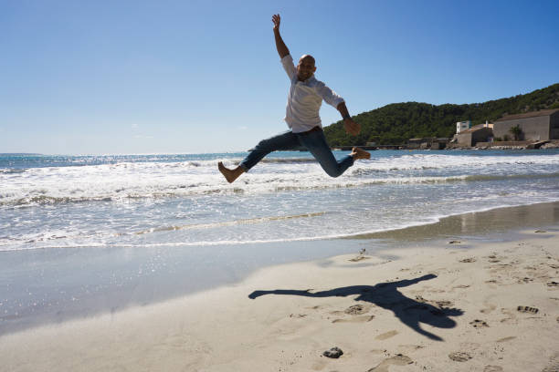 istock man taking a big jump on a beach 1282098784