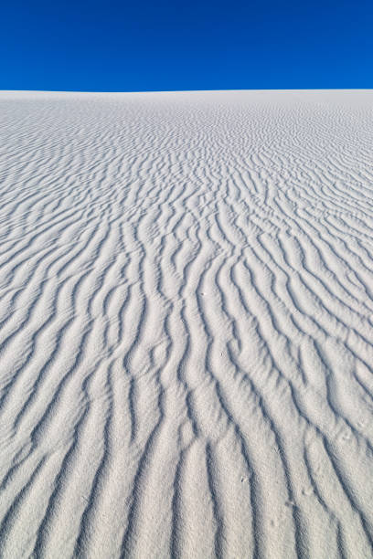 Ripples in white sand dunes against a clear sky, at White Sands National Park, New Mexico