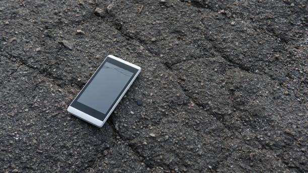 istock A white mobile phone with broken glass is lying on the asphalt. Damaged screen 1282100208