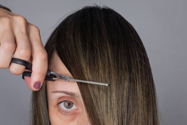 mulher com tesoura corta sua franja - cabelo partido do lado - fotografias e filmes do acervo