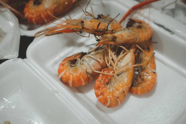 Grilled prawns or shrimp in foam box package. Grilling with charcoal