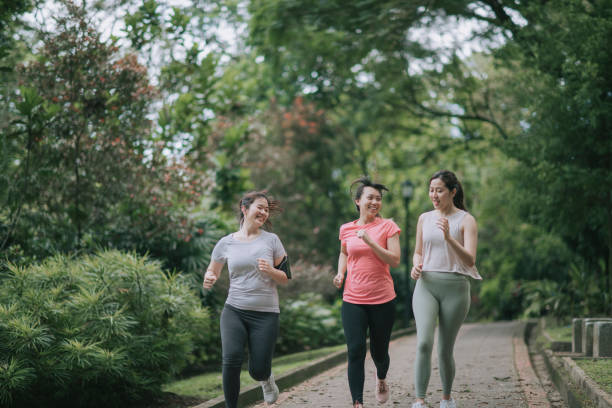 asiatiche giovani donne cinesi in esecuzione nel parco durante il fine settimana mattina - running jogging asian ethnicity women foto e immagini stock