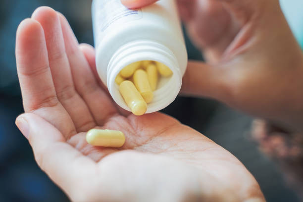 istock Taking medicines with glass of water 1282109910