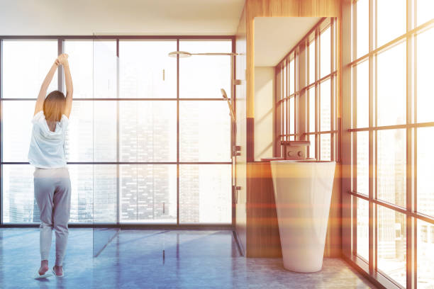 istock Woman standing in bathroom with shower and sink 1282110852
