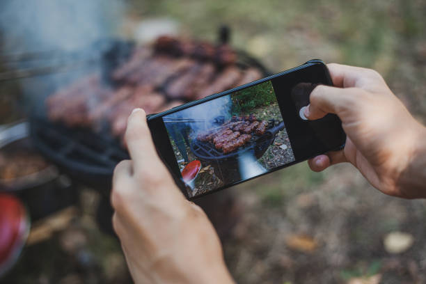 paprika y carne en la parrilla fotografiando con teléfono móvil - barbecue grill fotos fotografías e imágenes de stock