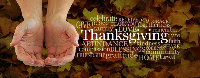 female hands cupped beside a THANKSGIVING word cloud against a rustic grunge Autumn leaf background