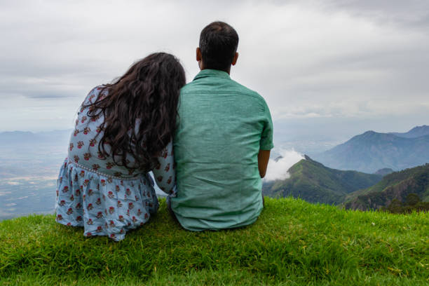 Couple Isolated soaking up natural beauty from hilltop Couple Isolated soaking up natural beauty from hilltop image is showing the human love towards the nature. Image taken at Kodaikanal tamilnadu India from top of the hill. kodaikanal photos stock pictures, royalty-free photos & images