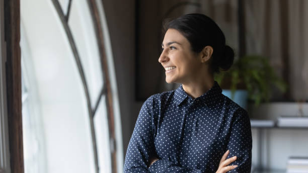 istock Smiling indian female look in distance dreaming or thinking 1282120095