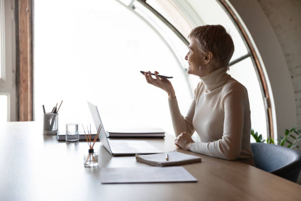 istock Smiling businesswoman talk on cellphone using speakerphone 1282120097