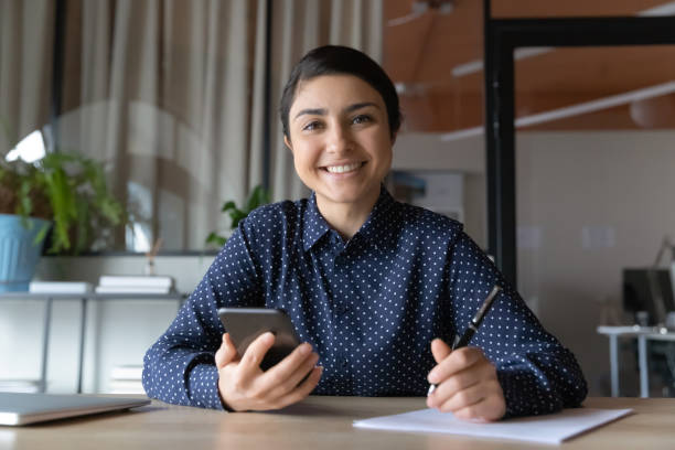 istock Portrait of smiling indian woman study using cellphone 1282120159