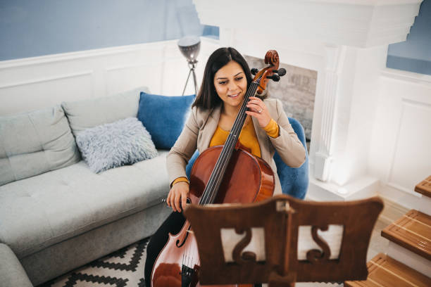 istock Young woman playing violoncello 1282120789