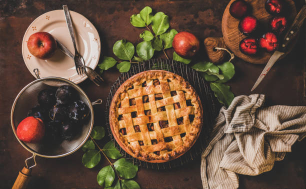 istock Flat-lay of whole apple and plum pie and tea setting 1282120898
