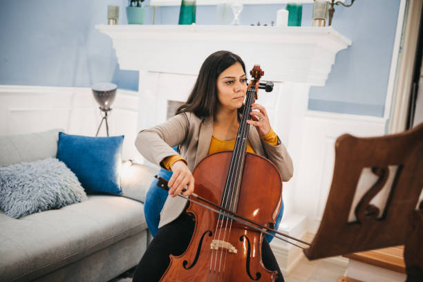 istock Young woman playing violoncello 1282121546