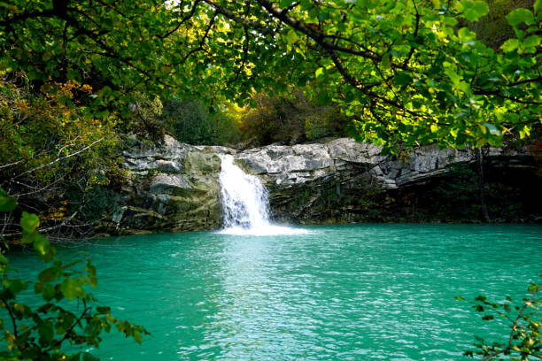 Beautiful waterfall in the woods flowing towards a turquoise lake in the forest in Croatian Istria region