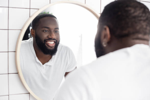 istock smiling afro-american man looking in mirror 1282126944