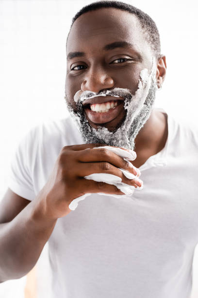 istock smiling afro-american man with shaving foam on face looking at camera 1282127004
