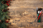 Christmas decorations and Cutlery on a dark rustic table. Christmas table place setting. Winter holidays background. Top view, flat lay, copy space