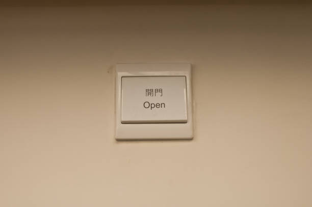 istock White plastic light electric switch in English and Chinese on white plain wall 1282127374