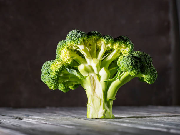 istock Dissected fresh broccoli on wooden background. 1282128062