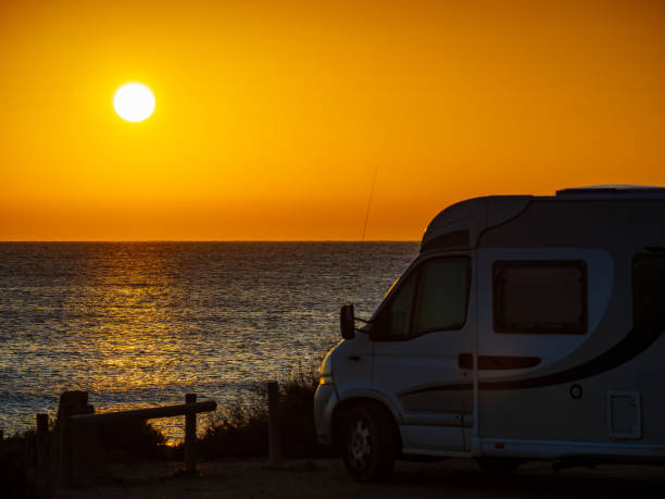 istock Camper car on beach at sunrise 1282129977