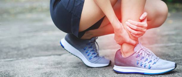 un corredor tenía mucho dolor en las piernas en el parque. - ankle fotografías e imágenes de stock